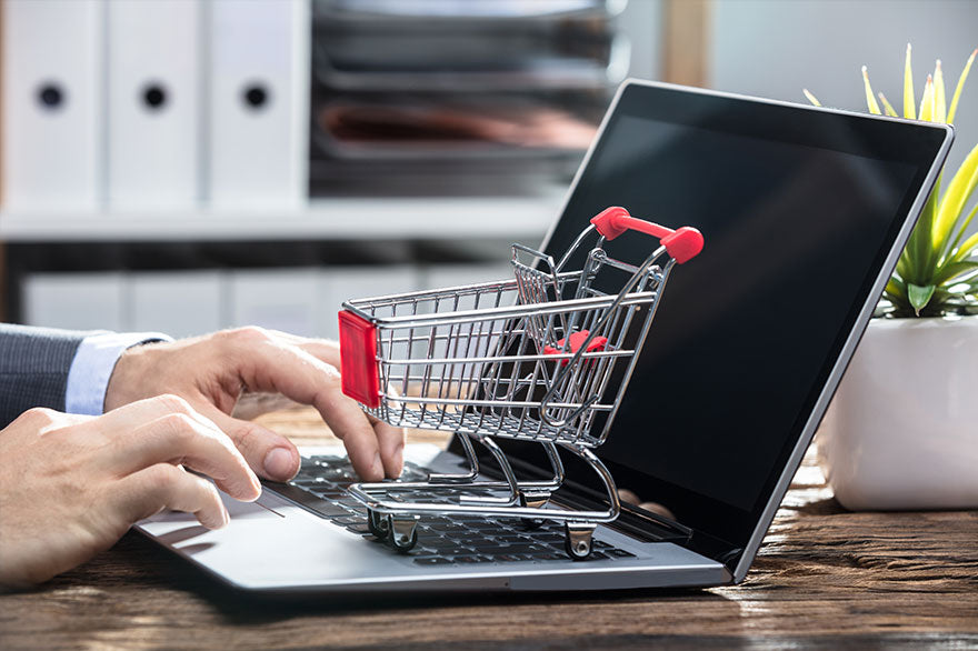 Businessperson's Hand Using Laptop Shopping Cart Keypad